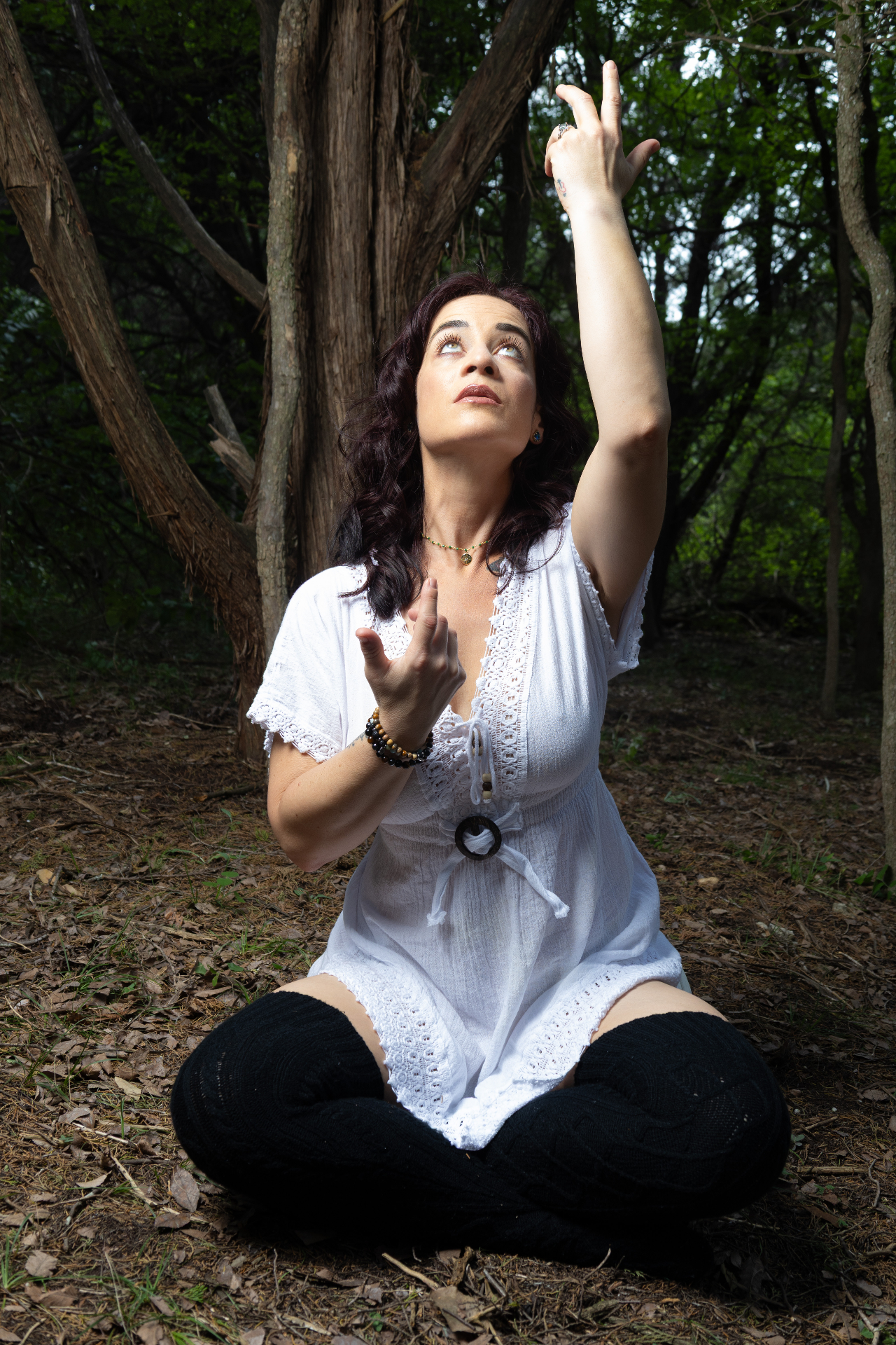 A woman in flowing linen standing in a misty forest